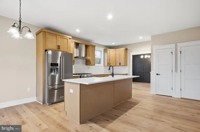 a kitchen with stainless steel appliances a refrigerator and a stove top oven