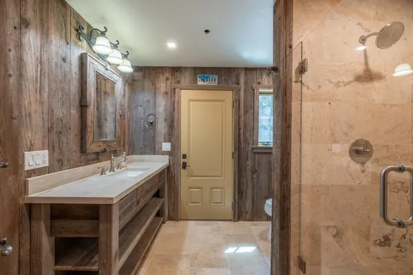 a bathroom with a double vanity sink a mirror and a shower