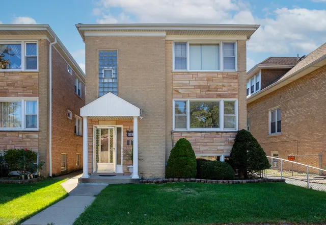 a front view of a house with a garden and yard