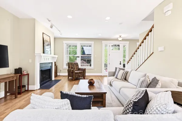 a living room with furniture fireplace and a large window