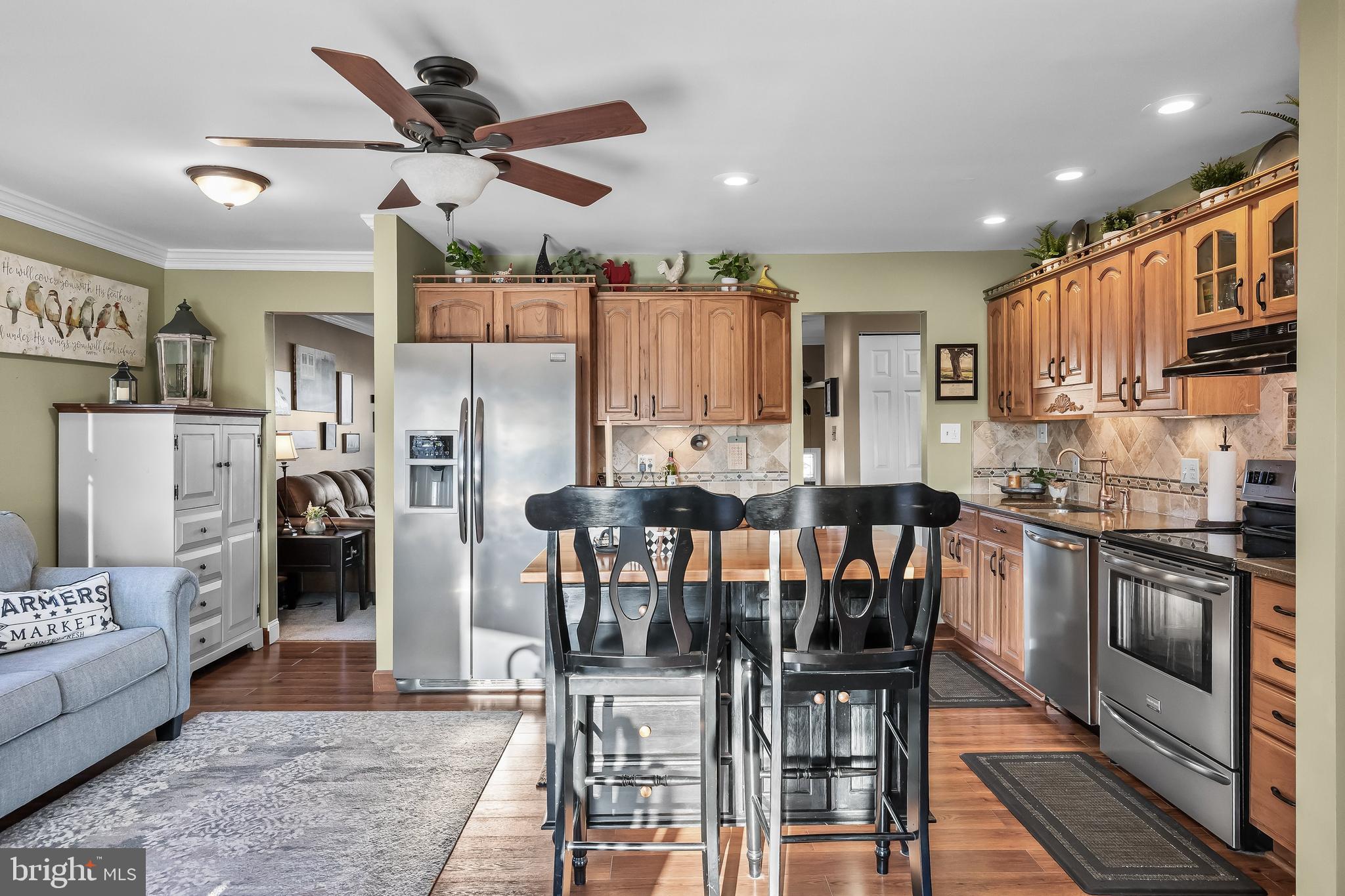50 Brighton Road Westampton, NJ 08060 - Photo 13 of 35 a kitchen with stainless steel appliances kitchen island granite countertop a refrigerator a stove a sink a dining table and chairs with wooden floor