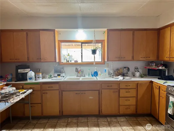 a kitchen with stainless steel appliances granite countertop a sink window and cabinets