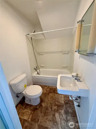 a bathroom with a sink toilet a mirror and shower