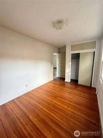 a view of empty room with wooden floor