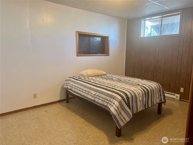 a bedroom with a bed and painting on the wall