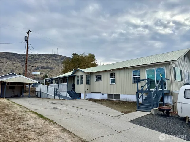 a view of a house with backyard and sitting area