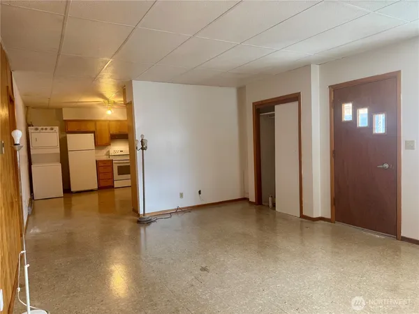 a view of empty room with kitchen