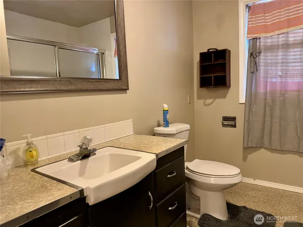 a bathroom with a sink a toilet and shower