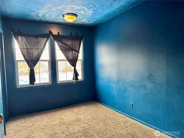 an empty room with windows and mirror