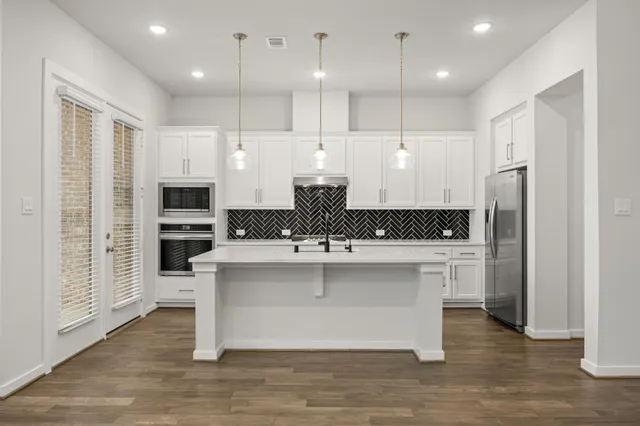 a kitchen with white cabinets and appliances