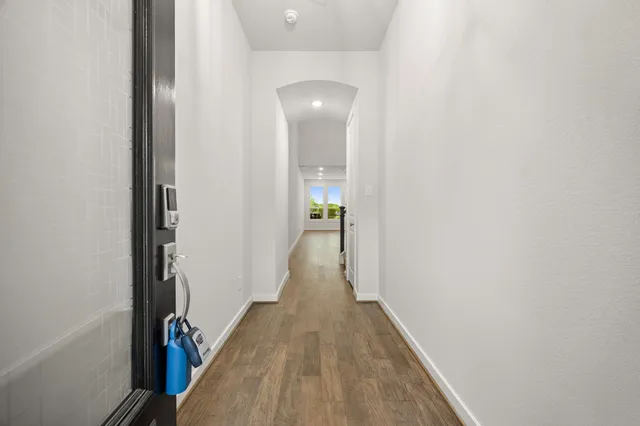 a view of a hallway with wooden floor and staircase