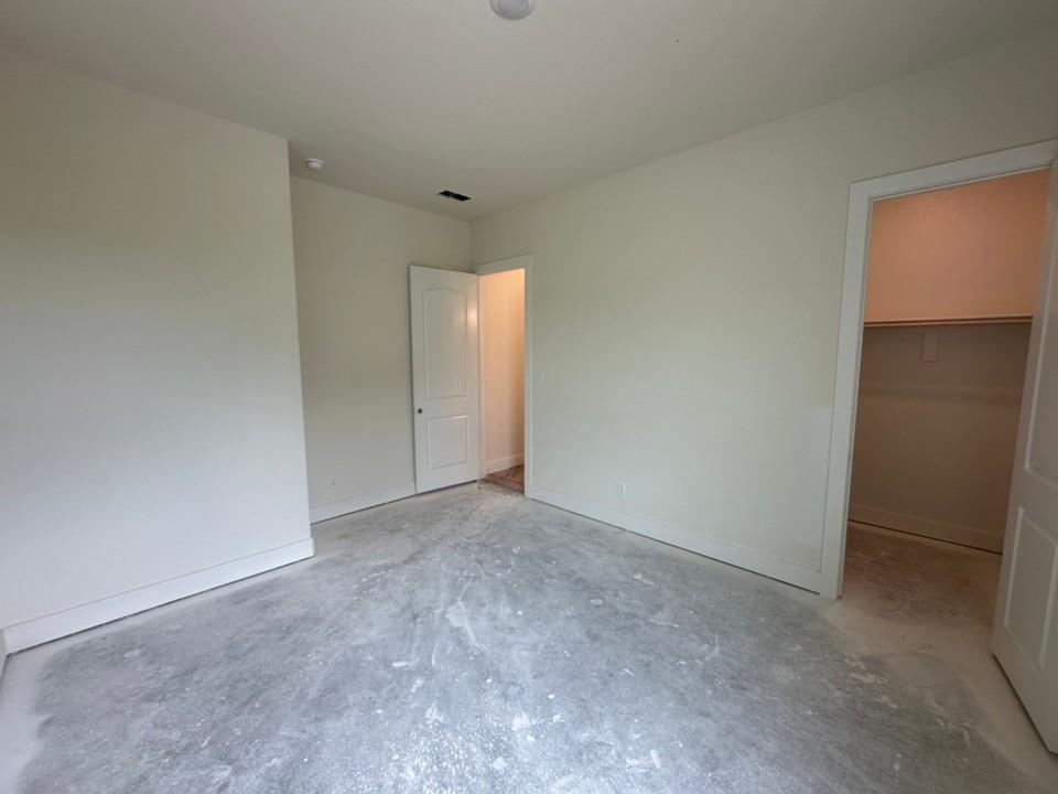 205 Cobb Road Leonard, TX 75452 - Photo 22 of 28 Spacious room featuring neutral painted walls, white baseboards, a white interior door, and an open closet space with a built-in shelf and hanging rod