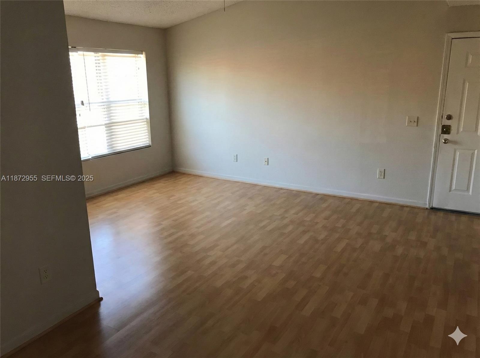 4201 West McNab Road, Unit 27 Pompano Beach, FL 33069 - Photo 13 of 15 an empty room with wooden floor and windows