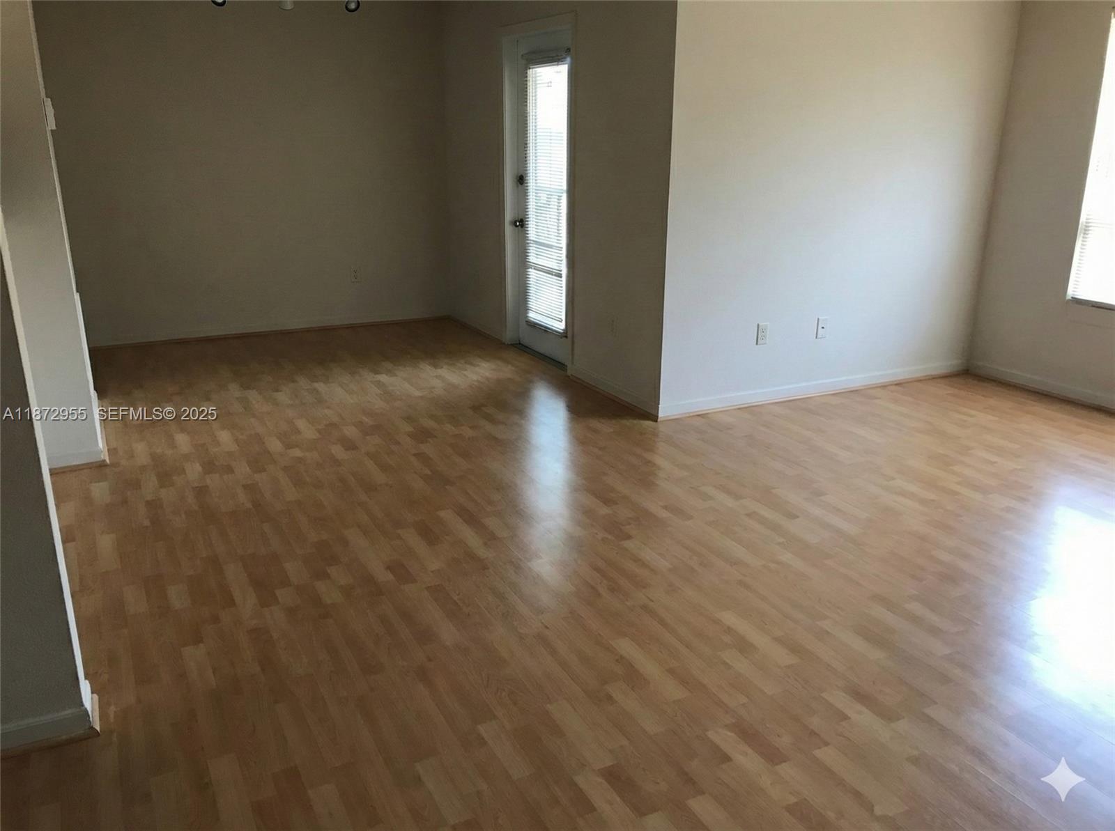 4201 West McNab Road, Unit 27 Pompano Beach, FL 33069 - Photo 14 of 15 an empty room with wooden floor and windows