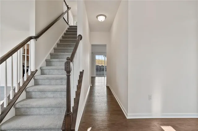 a view of staircase with wooden floor and white walls