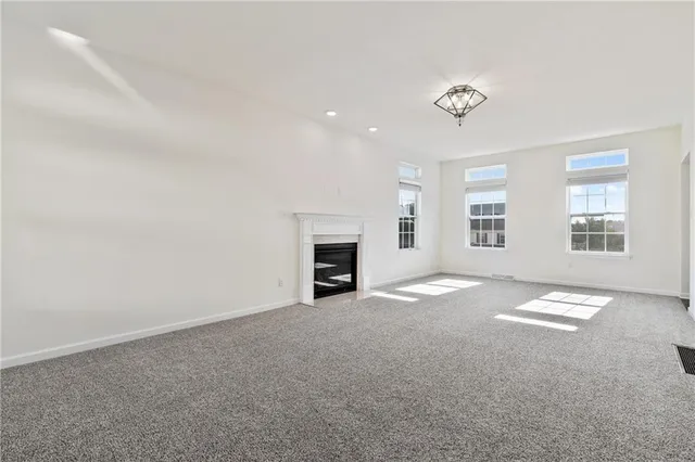 an empty room with windows and fireplace