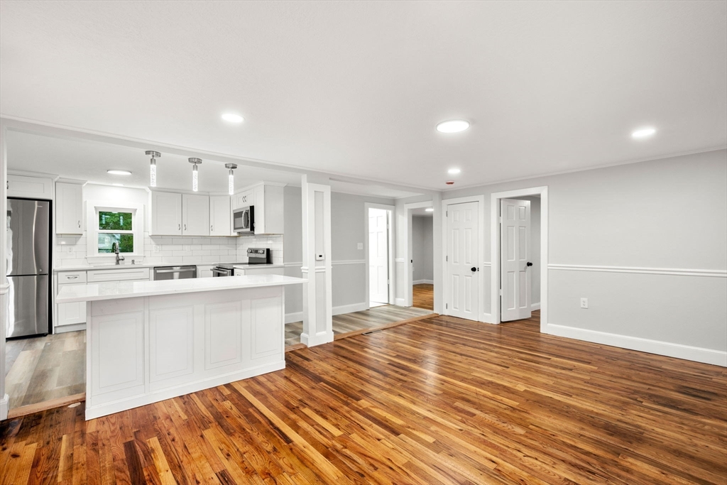 6 Leon Road Holbrook, MA 02343 - Photo 8 of 28 a large white kitchen with kitchen island a sink wooden floor and a refrigerator