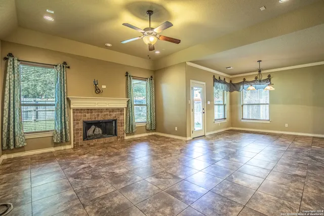 a view of an empty room with a fireplace and a window