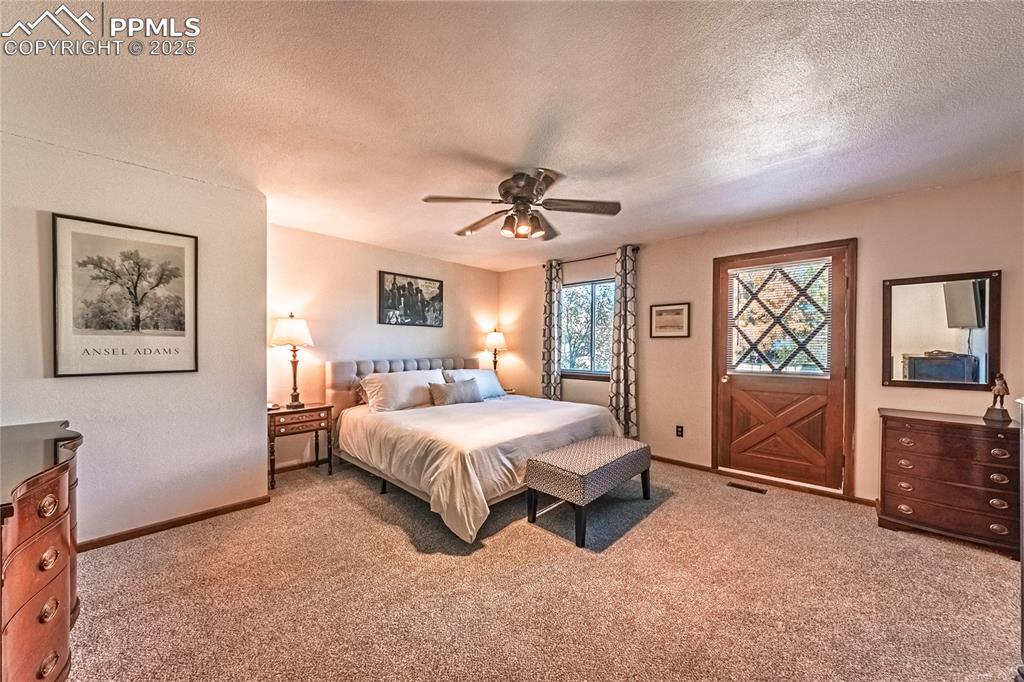 422 Saddlemountain Road Colorado Springs, CO 80919 - Photo 13 of 30 a spacious bedroom with a bed and a chandelier