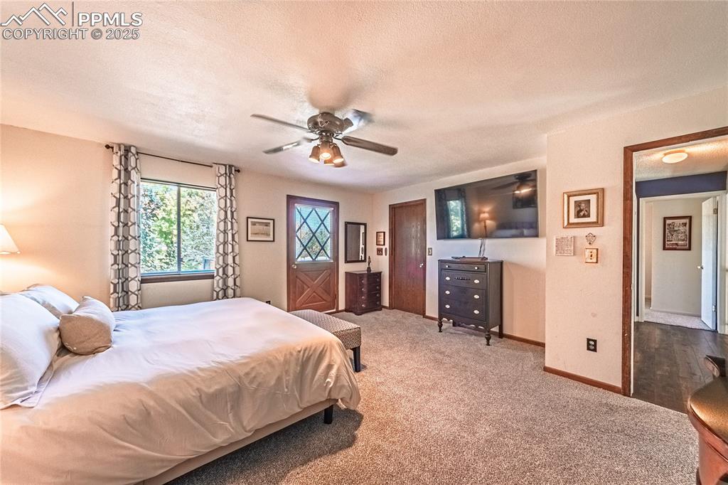 422 Saddlemountain Road Colorado Springs, CO 80919 - Photo 14 of 30 a spacious bedroom with a bed a dresser and a large window