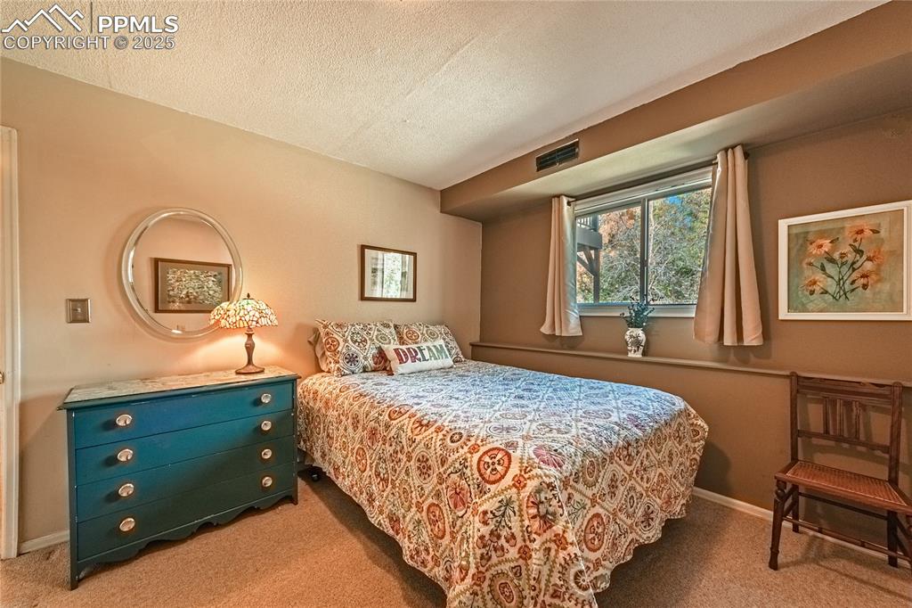 422 Saddlemountain Road Colorado Springs, CO 80919 - Photo 22 of 30 a bedroom with a bed and a dresser in it