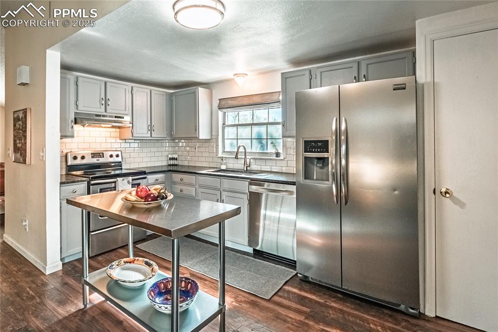422 Saddlemountain Road Colorado Springs, CO 80919 - Photo 7 of 30 a kitchen with stainless steel appliances granite countertop a refrigerator a sink a stove and white cabinets
