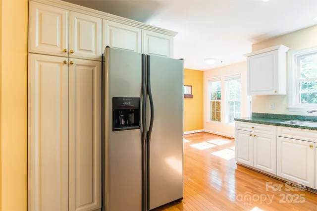 a kitchen with stainless steel appliances granite countertop a refrigerator and a sink