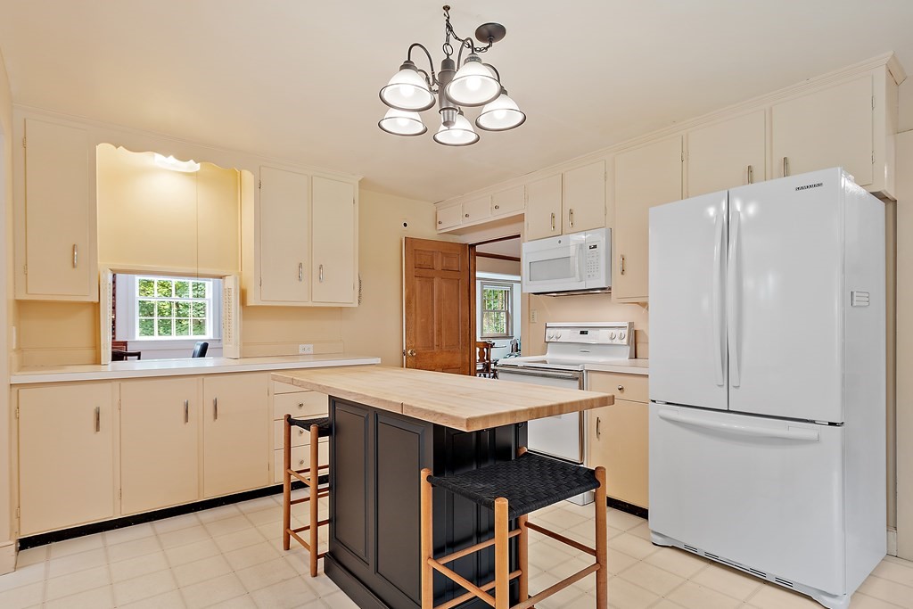 23 Bennington Road Lexington, MA 02421 - Photo 4 of 42 a kitchen with refrigerator cabinets and wooden floor