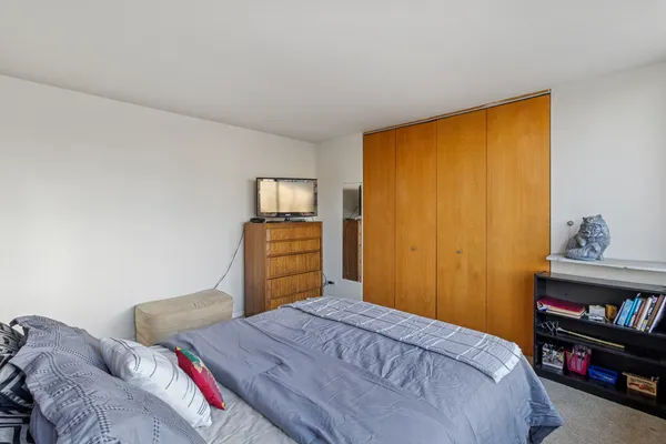 a bedroom with a bed and a cabinet