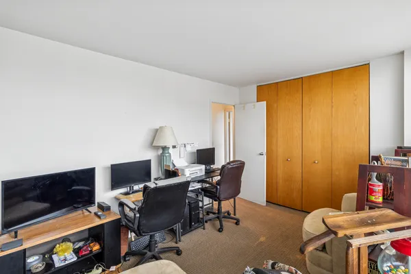 a view of a workspace with furniture and a window