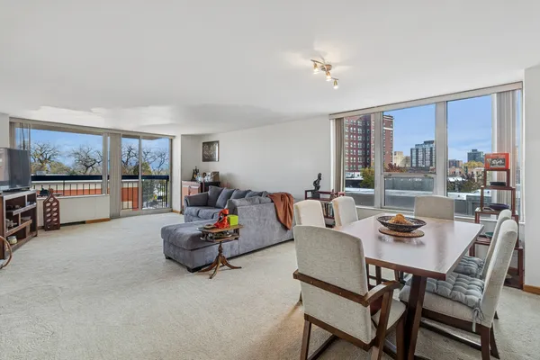 a living room with furniture and a floor to ceiling window