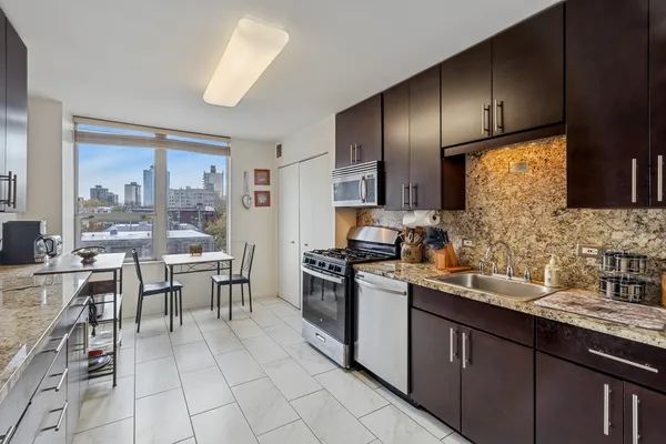 a kitchen with stainless steel appliances granite countertop a sink counter space cabinets and a large window