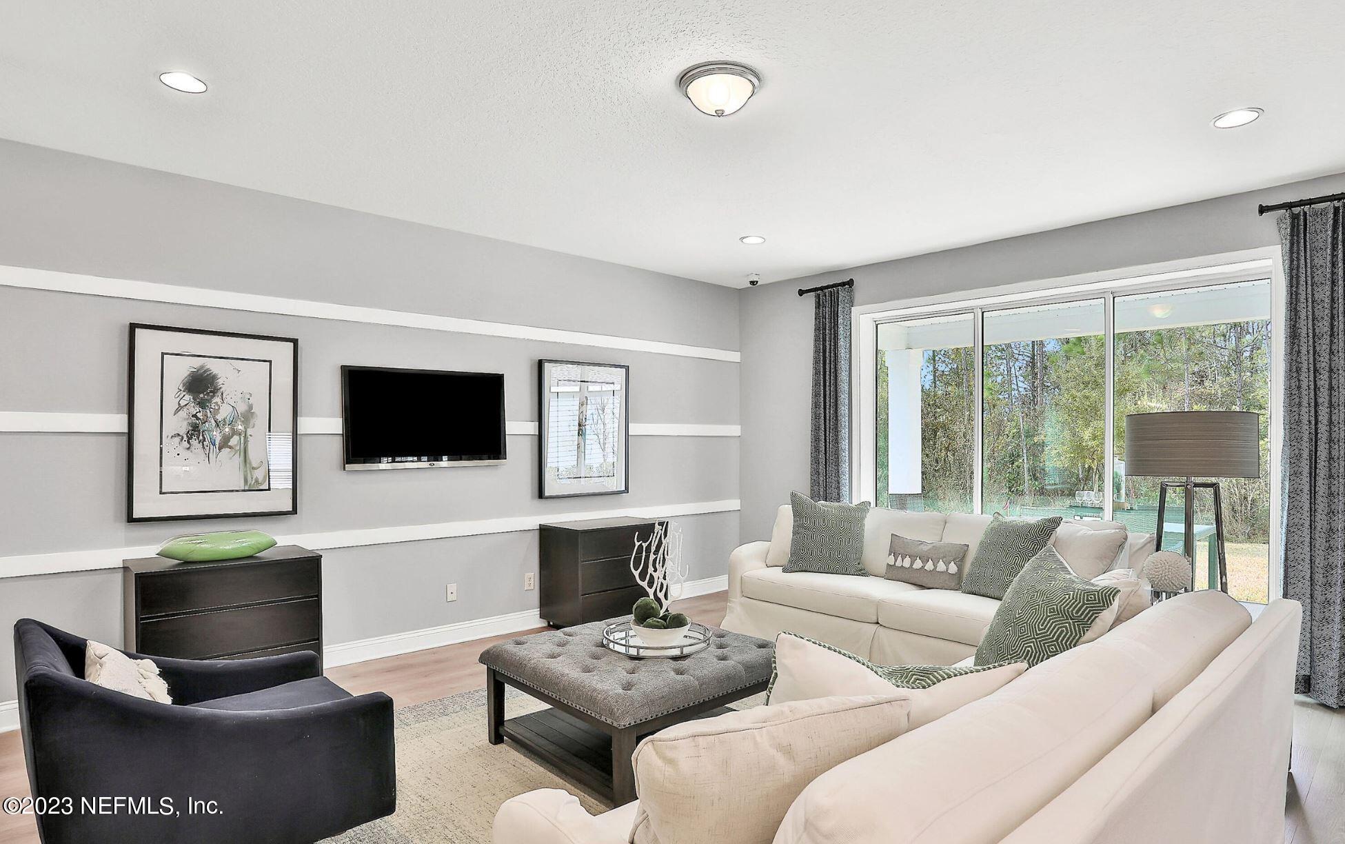 76 Archstone Way St. Augustine, FL 32092 - Photo 19 of 49 a living room with furniture a flat screen tv and a large window