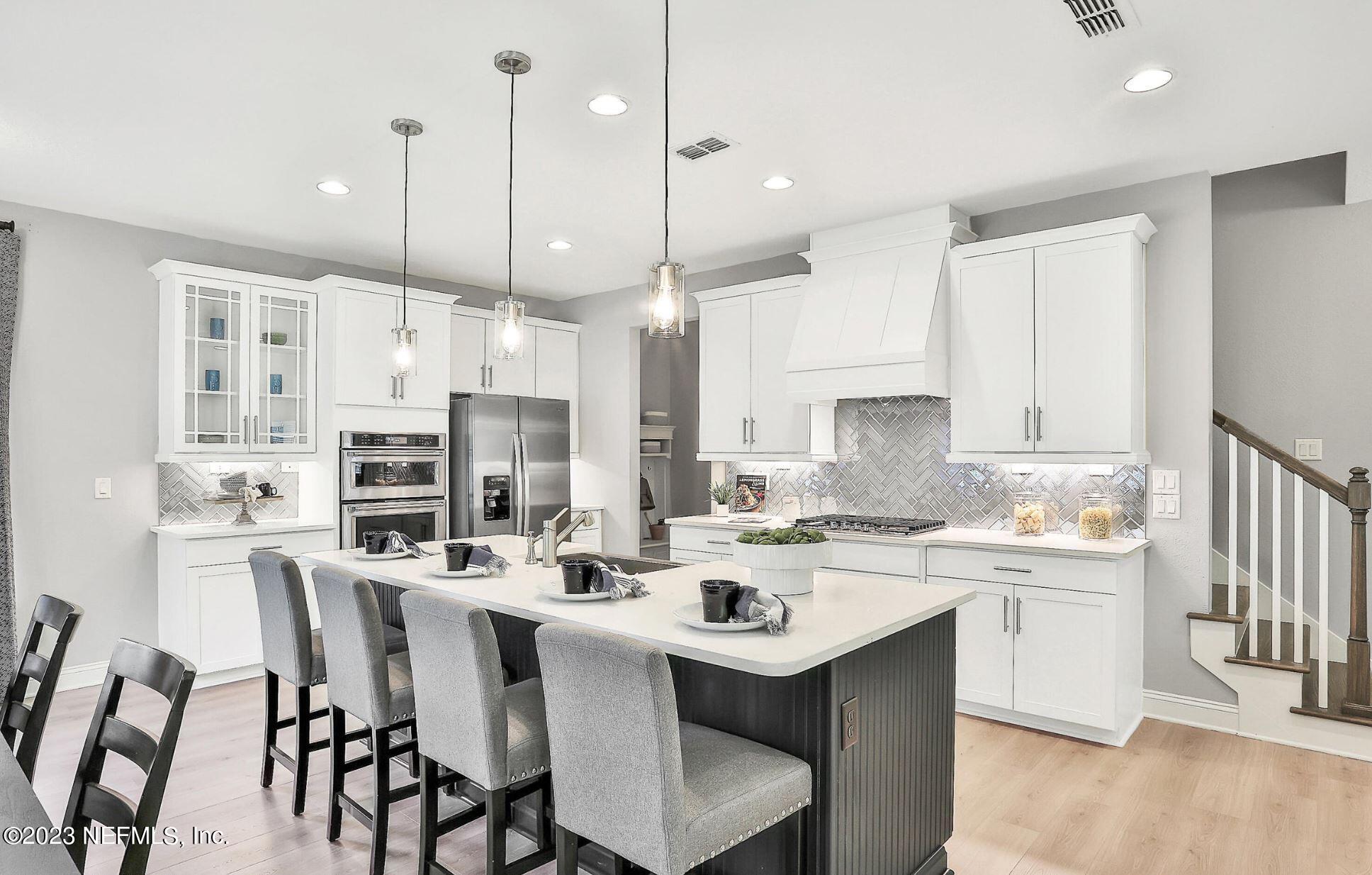 76 Archstone Way St. Augustine, FL 32092 - Photo 23 of 49 a kitchen with stainless steel appliances kitchen island a table chairs refrigerator and microwave