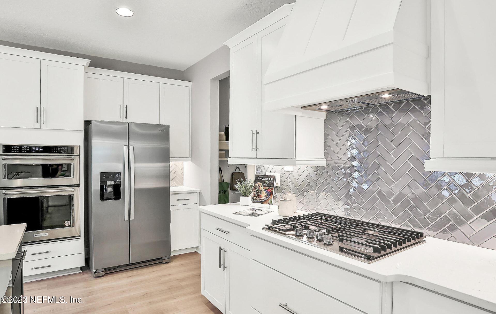 76 Archstone Way St. Augustine, FL 32092 - Photo 25 of 49 a kitchen with white cabinets and stainless steel appliances