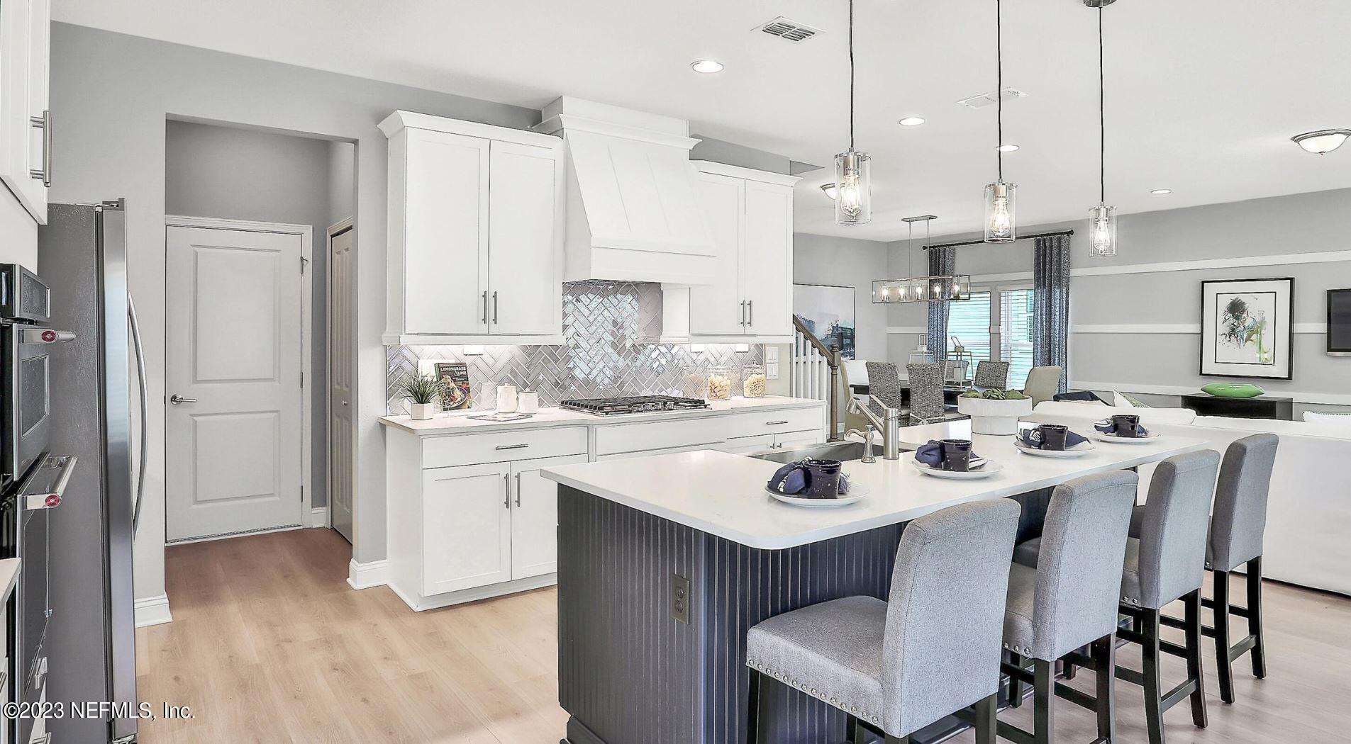 76 Archstone Way St. Augustine, FL 32092 - Photo 28 of 49 a kitchen with white cabinets appliances and center island