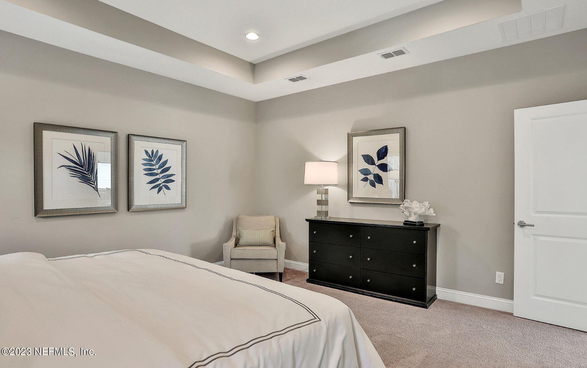 76 Archstone Way St. Augustine, FL 32092 - Photo 34 of 49 a bedroom with a bed and a lamp on dresser