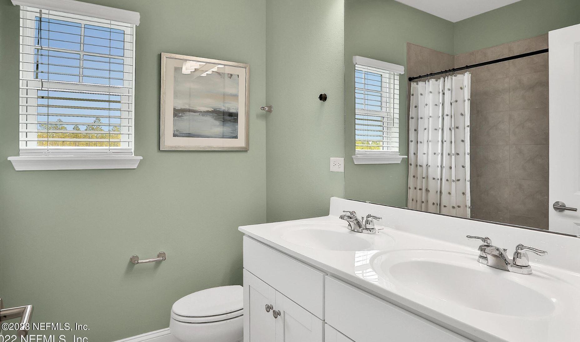 76 Archstone Way St. Augustine, FL 32092 - Photo 43 of 49 a bathroom with a granite countertop sink a toilet and a mirror