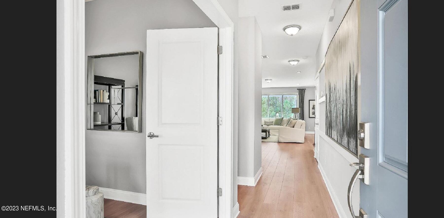 76 Archstone Way St. Augustine, FL 32092 - Photo 10 of 49 a view of a hallway with wooden floor and a living room