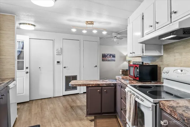 a kitchen with white cabinets and appliances