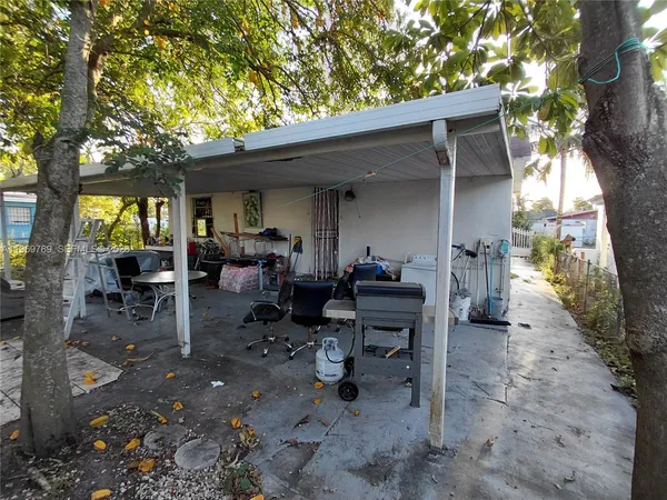a view of a patio with table and chairs and a large tree