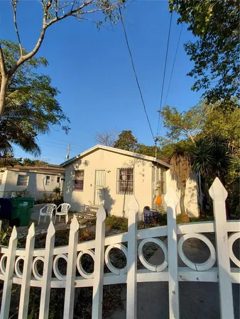 a view of a house with backyard and sitting area