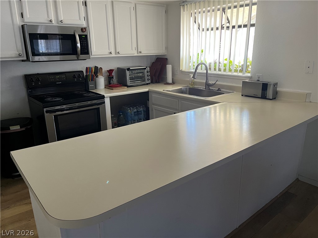 6412 West Pearcrest Road Las Vegas, NV 89108 - Photo 10 of 17 Well-lit kitchen with a spacious breakfast bar and essential appliances.