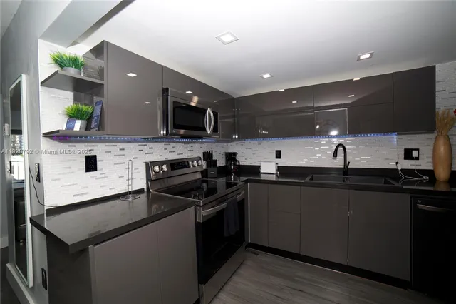 a kitchen with stainless steel appliances a sink stove and cabinets