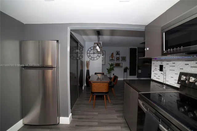 a kitchen with stainless steel appliances granite countertop a refrigerator a stove and a microwave