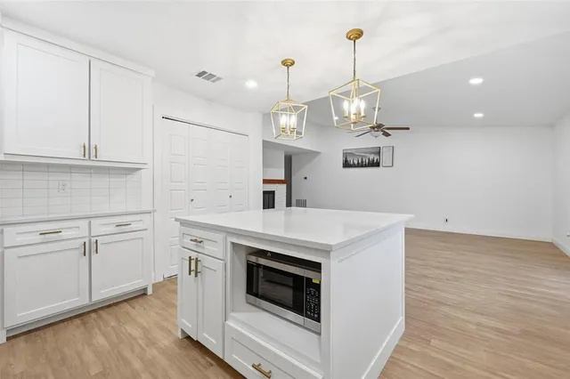 a kitchen with a stove cabinets and wooden floor