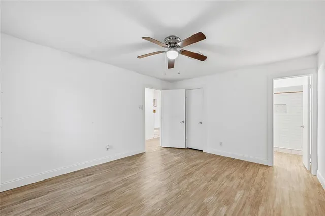 a view of a room with wooden floor and a ceiling fan