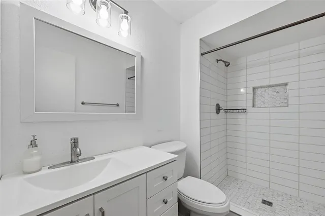 a bathroom with a sink a toilet and shower