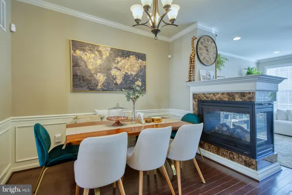 a dining room with furniture a fireplace and wooden floor