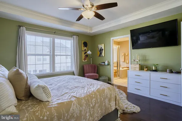 a spacious bedroom with a bed and a flat screen tv